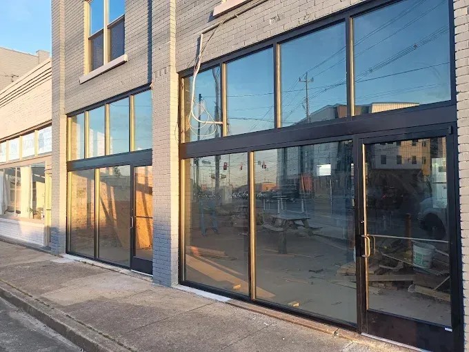 Modern storefront with large reflective glass windows on a sunny street corner