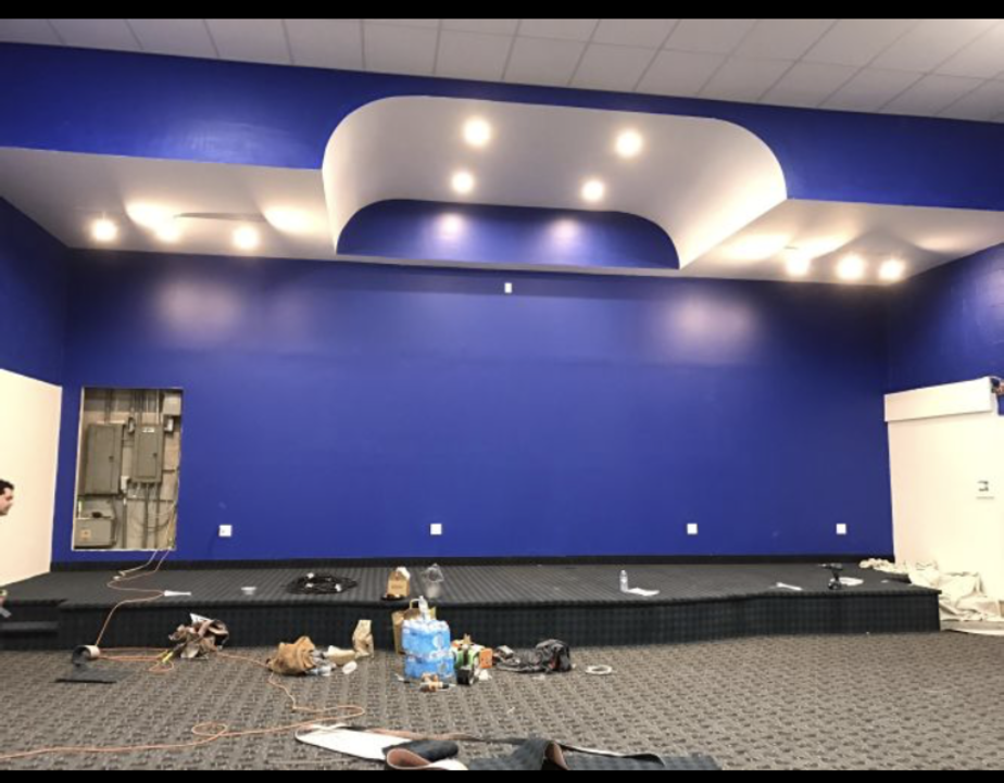 An empty room with blue walls and a stage
