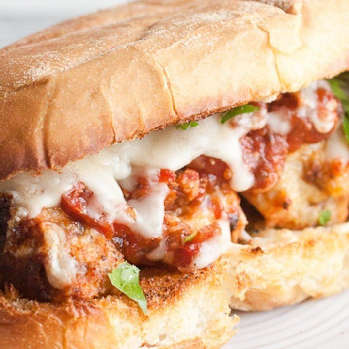 A close up of a sandwich with meat and cheese on a plate.