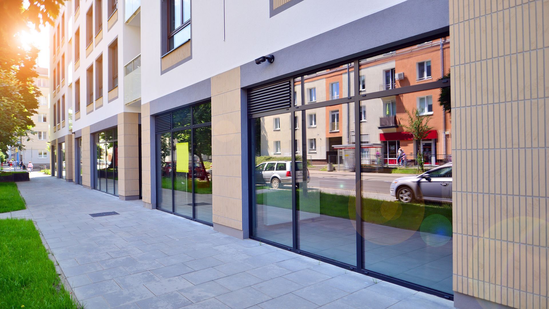 A building with a lot of windows and a car parked in front of it. A building with a lot of windows and a car parked in front of it.