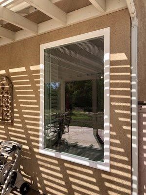 A large window on the side of a house with a white frame.