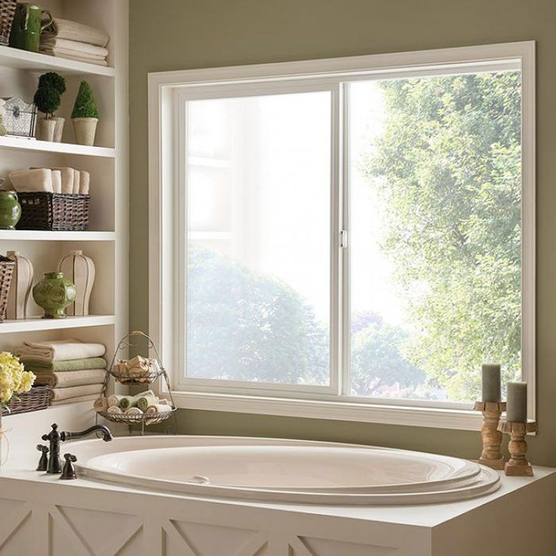 A bathtub in a bathroom next to a window A bathtub in a bathroom next to a window