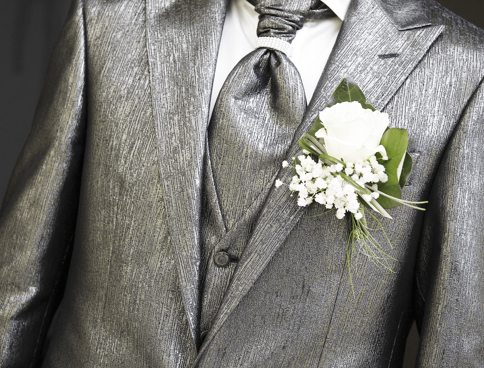 Un uomo in giacca e cravatta ha un fiore in tasca