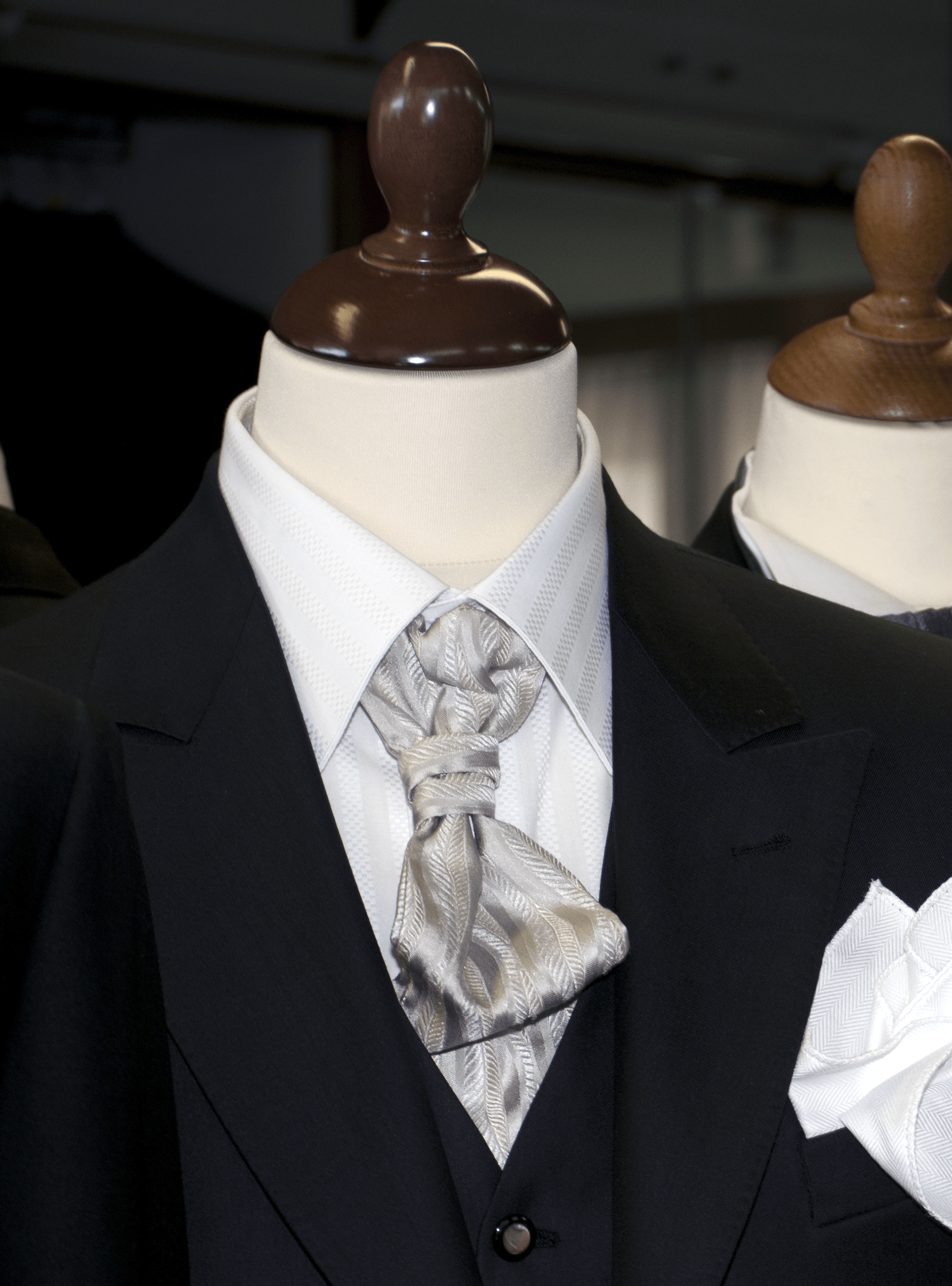 Un abito nero con una camicia bianca e una cravatta su un manichino