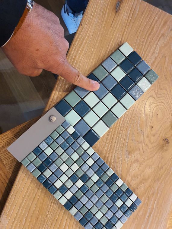 Campioni di parquet impilati in uno showroom, che mostrano diverse tonalità e venature del legno.