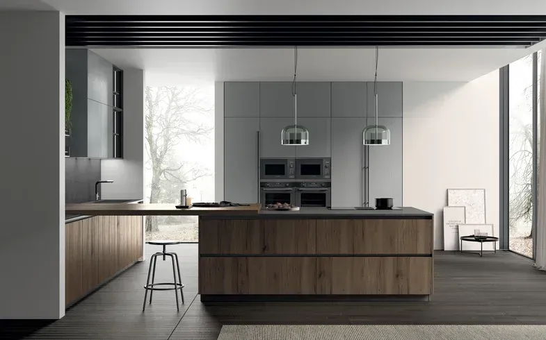 Cucina moderna e minimalista con isola in legno, mobili grigi e ampie finestre.