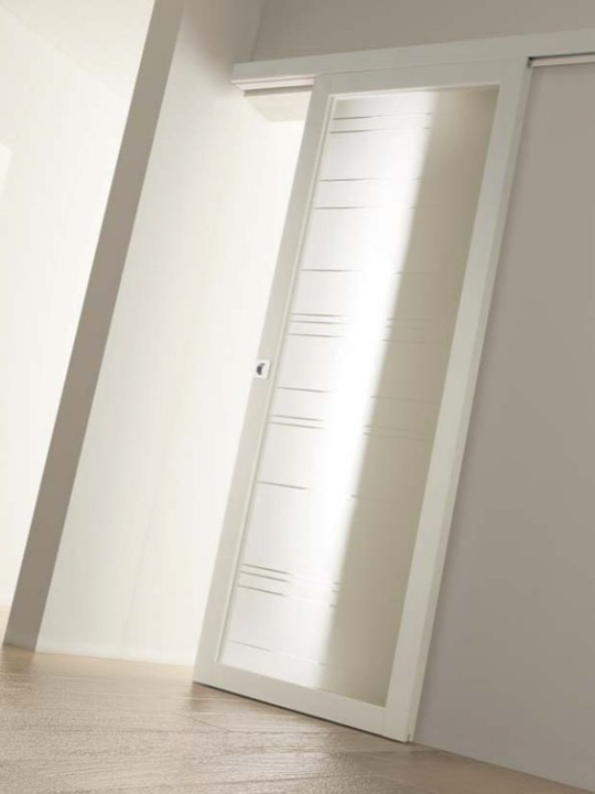 Porta interna moderna bianca con pannelli in vetro satinato in una stanza luminosa