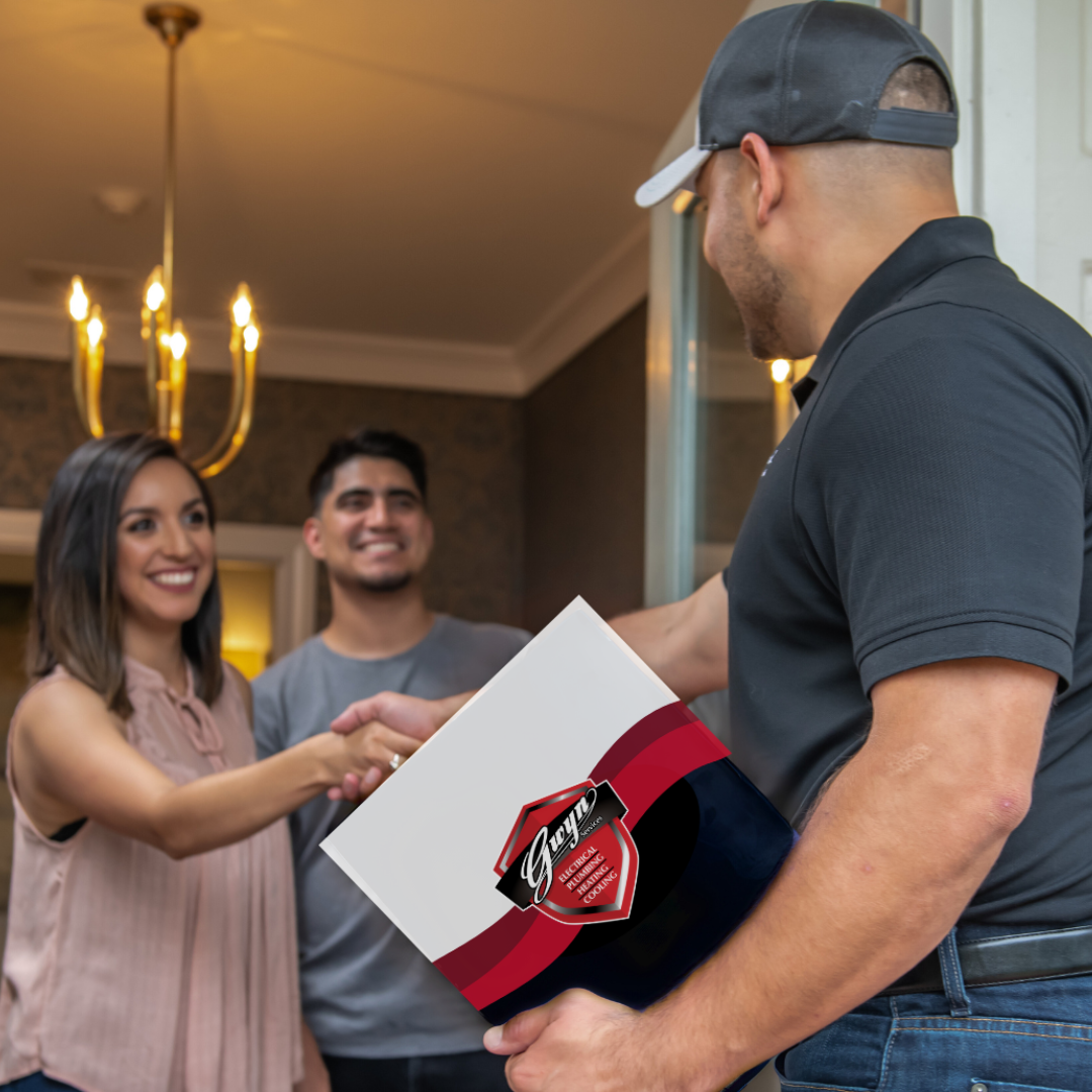 Delivery person handing a pizza box to smiling customers at a home doorway