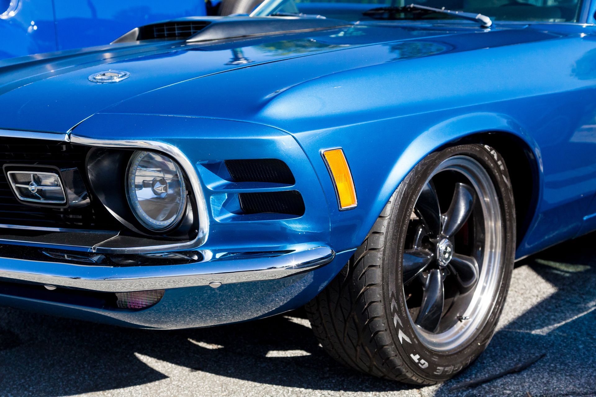 Blue classic muscle car parked outdoors, front view with chrome details and black wheels