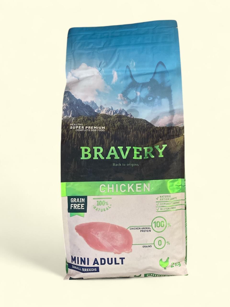 Bolsa de comida para perros adultos Bravery Chicken Mini con envase azul y verde sobre fondo claro.