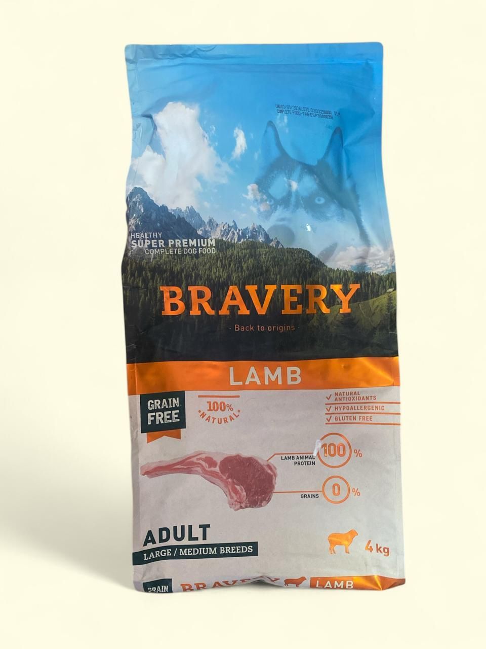 Bolsa de comida para perros adultos Bravery de cordero con diseño de montaña azul y etiqueta naranja.