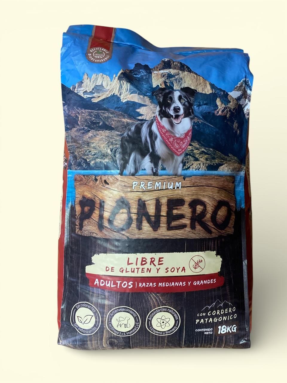 Bolsa de café Piñero roja y azul con etiqueta de montaña y perro sobre fondo blanco.