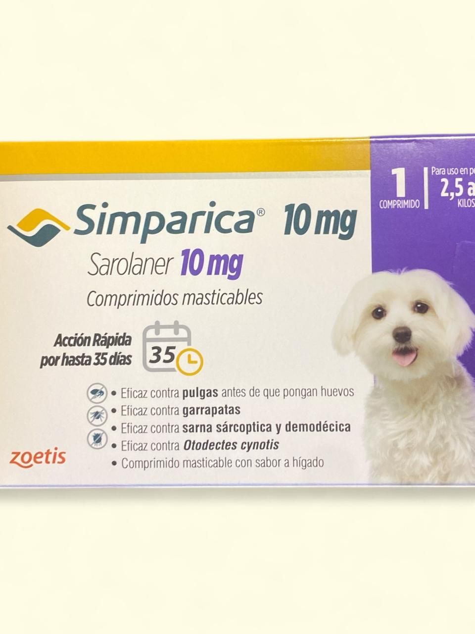 Caja de comprimidos masticables para perros Simparica de 10 mg con un pequeño perro blanco en el paquete.