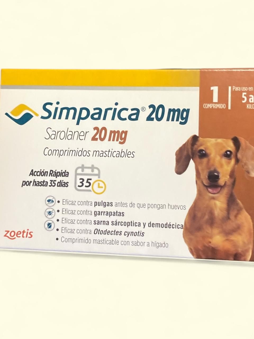 Caja de medicamento para perros Simparica 20 mg con un perro marrón en el frente, envase blanco y amarillo.