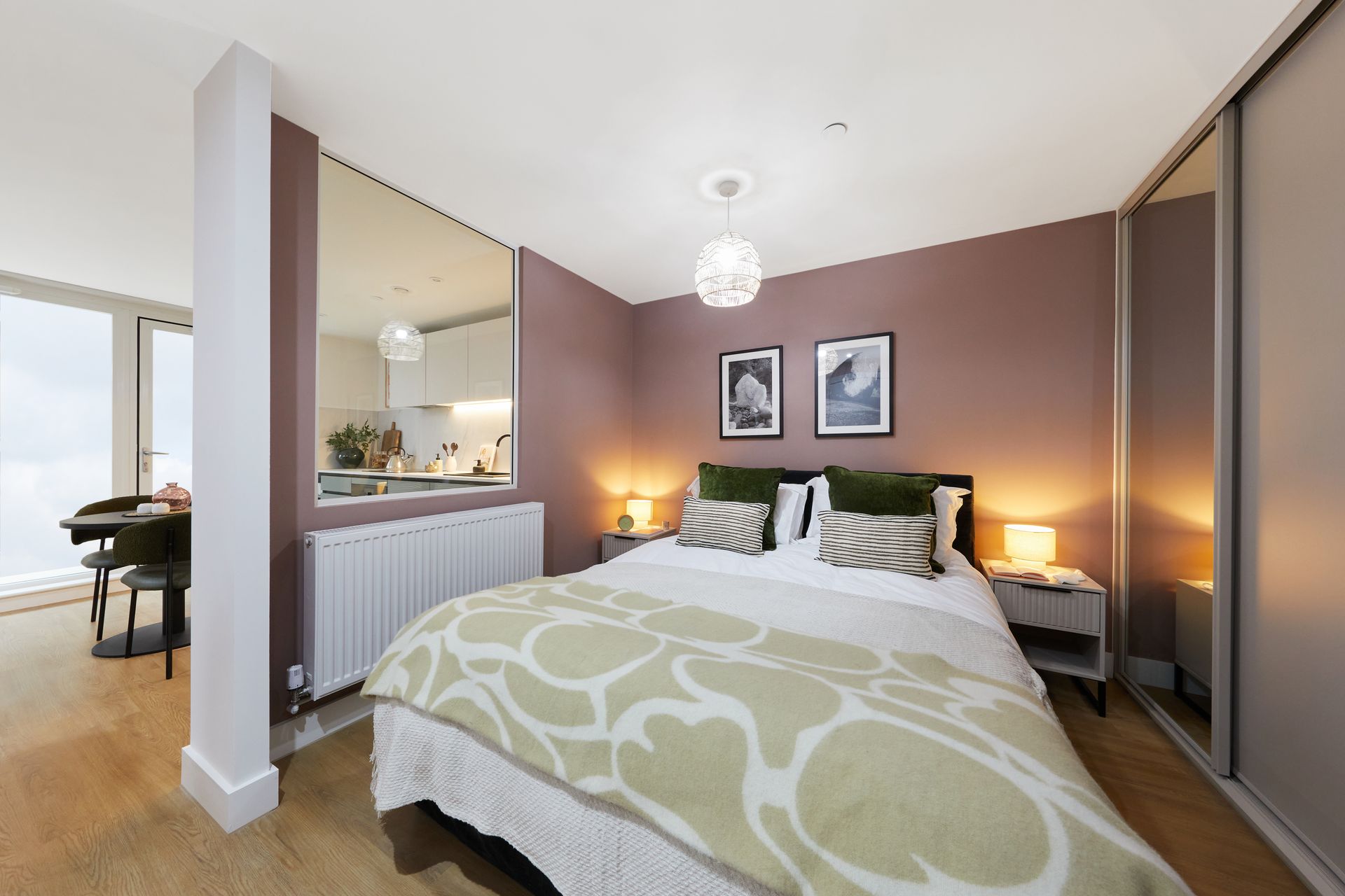 Modern bedroom with mauve walls, white bed, mirrored closet, and lamp-lit bedside tables