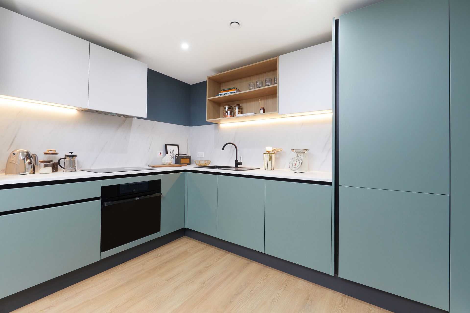 A kitchen with blue cabinets and white counter tops