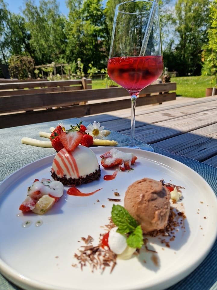 ein Teller mit Desserts und ein Glas Wein auf einem Tisch .
