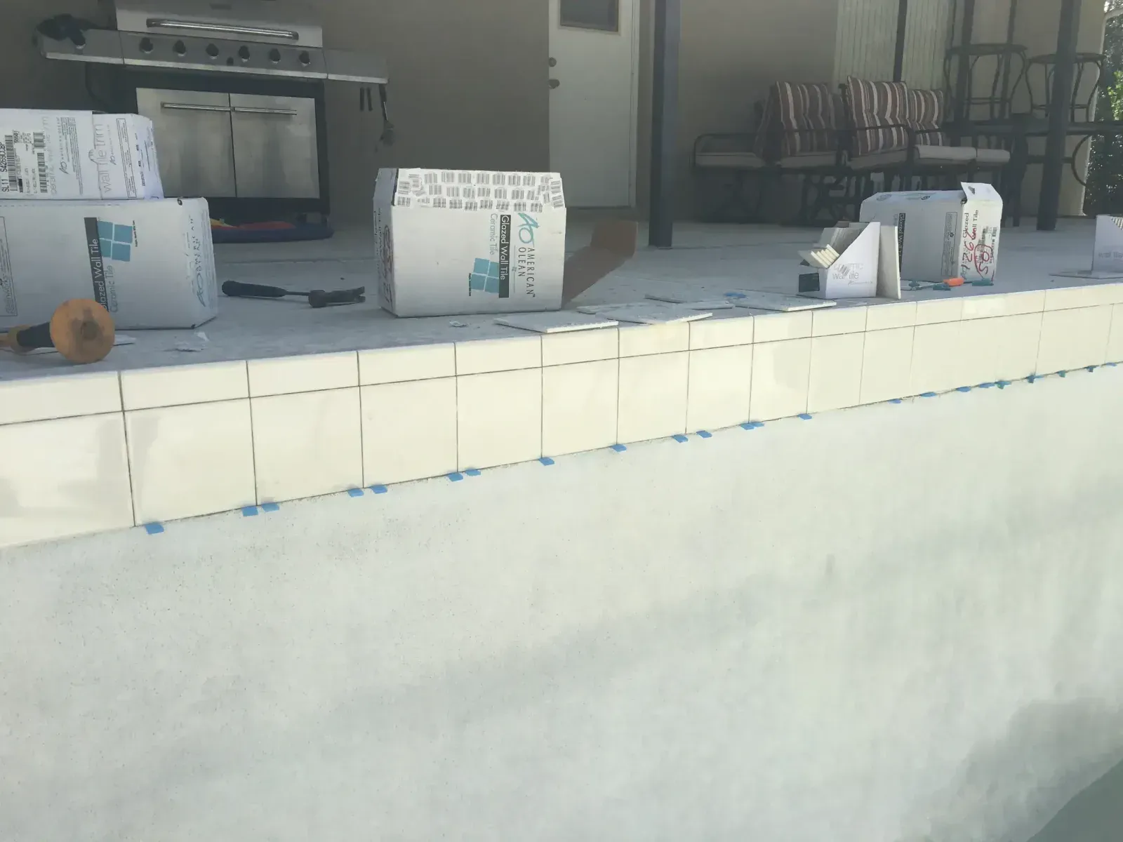 Outdoor service counter with several white bags on a tiled ledge in front of a building.