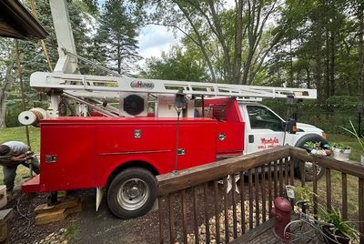 A red and white truck is parked next to a wooden deck. A red and white truck is parked next to a wooden deck.
