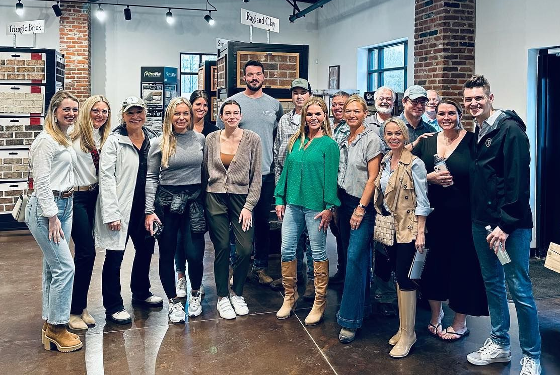 Group of people posing together inside a shop, smiling.