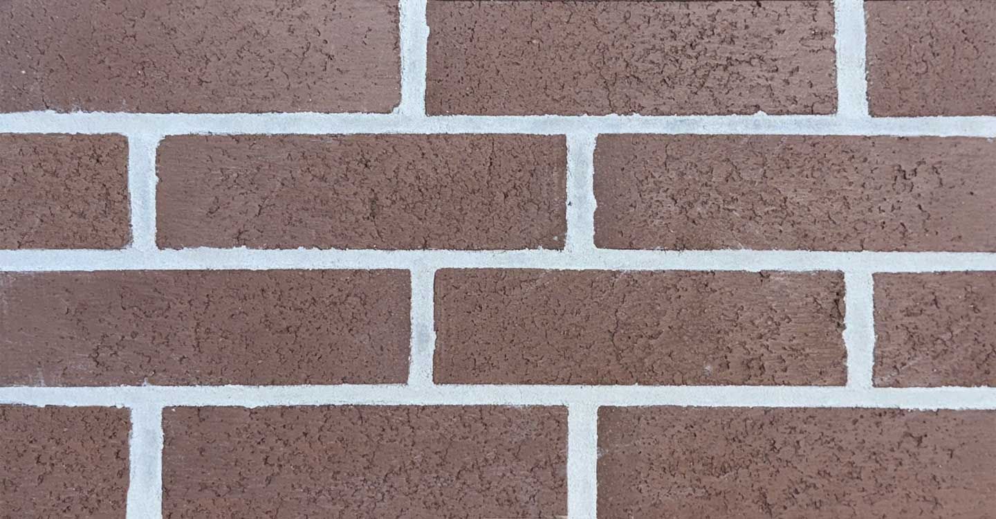 Brown brick wall with white mortar.