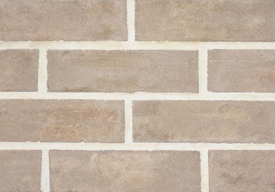 Tan rectangular bricks with white mortar in a running bond pattern.