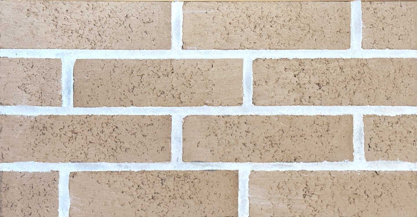 Tan brick wall with white mortar.