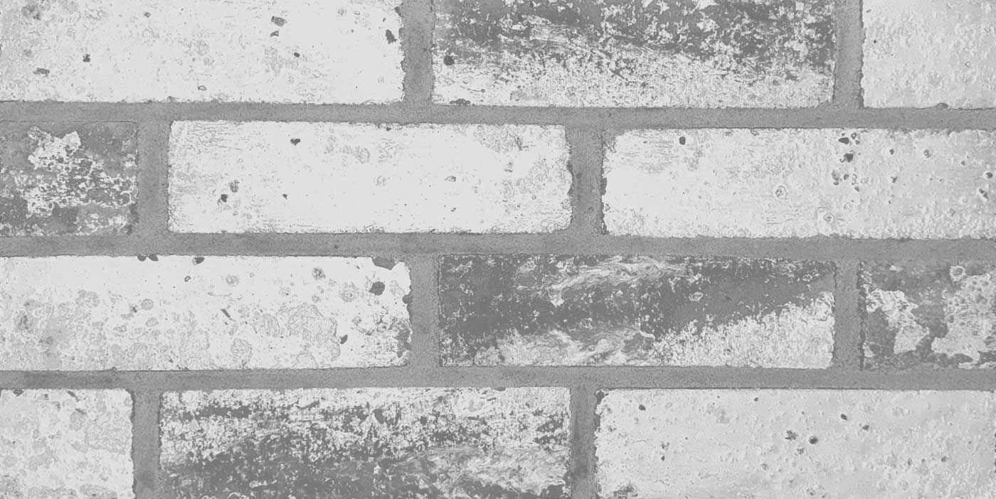 Gray brick wall with darker areas.