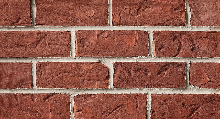 Close-up of a red brick wall with white mortar.