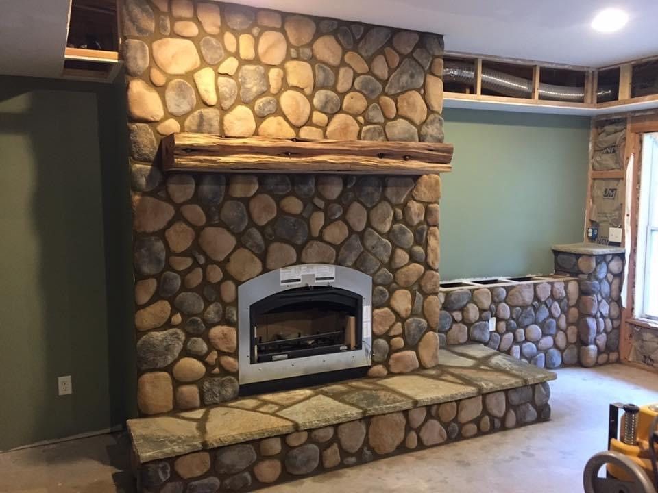 Stone fireplace with a wooden mantle and hearth.