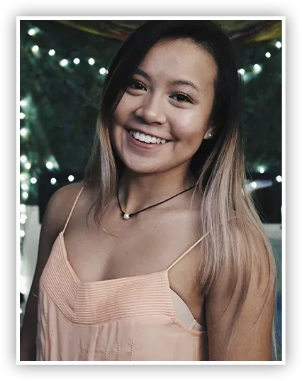 A woman in a pink tank top smiles for the camera