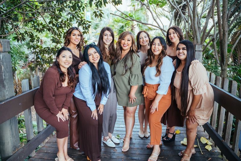 A group of women are posing for a picture on a bridge.