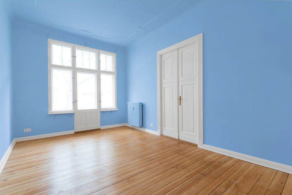 An Empty Room With Blue Walls And Wooden Floors — Paxi Homes Brad Clarke in Wauchope, NSW