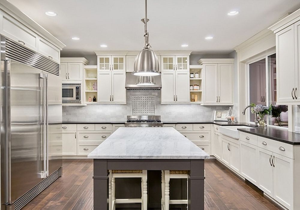 A Kitchen With White Cabinets And Stainless Steel Appliances — Paxi Homes Brad Clarke in Port Macquarie, NSW