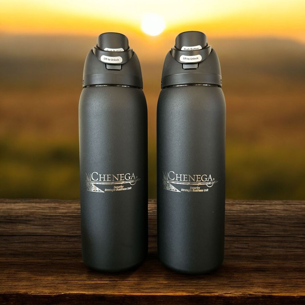 Two black water bottles are sitting on a wooden table.