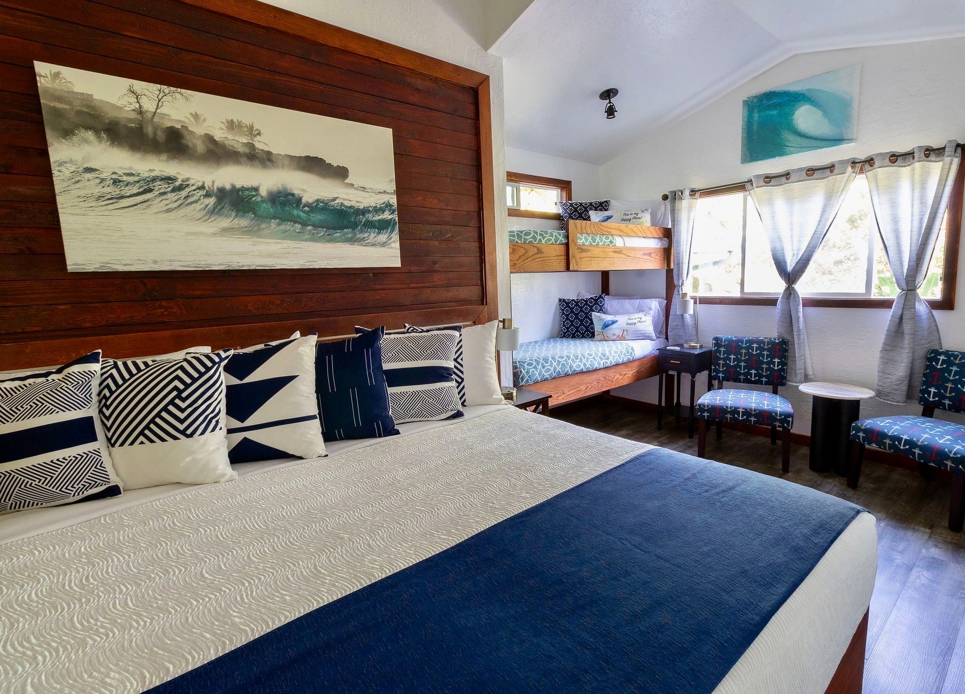 A bedroom with a queen bed featuring peach pillows against a wood headboard and a built-in wooden bunk bed to the right.