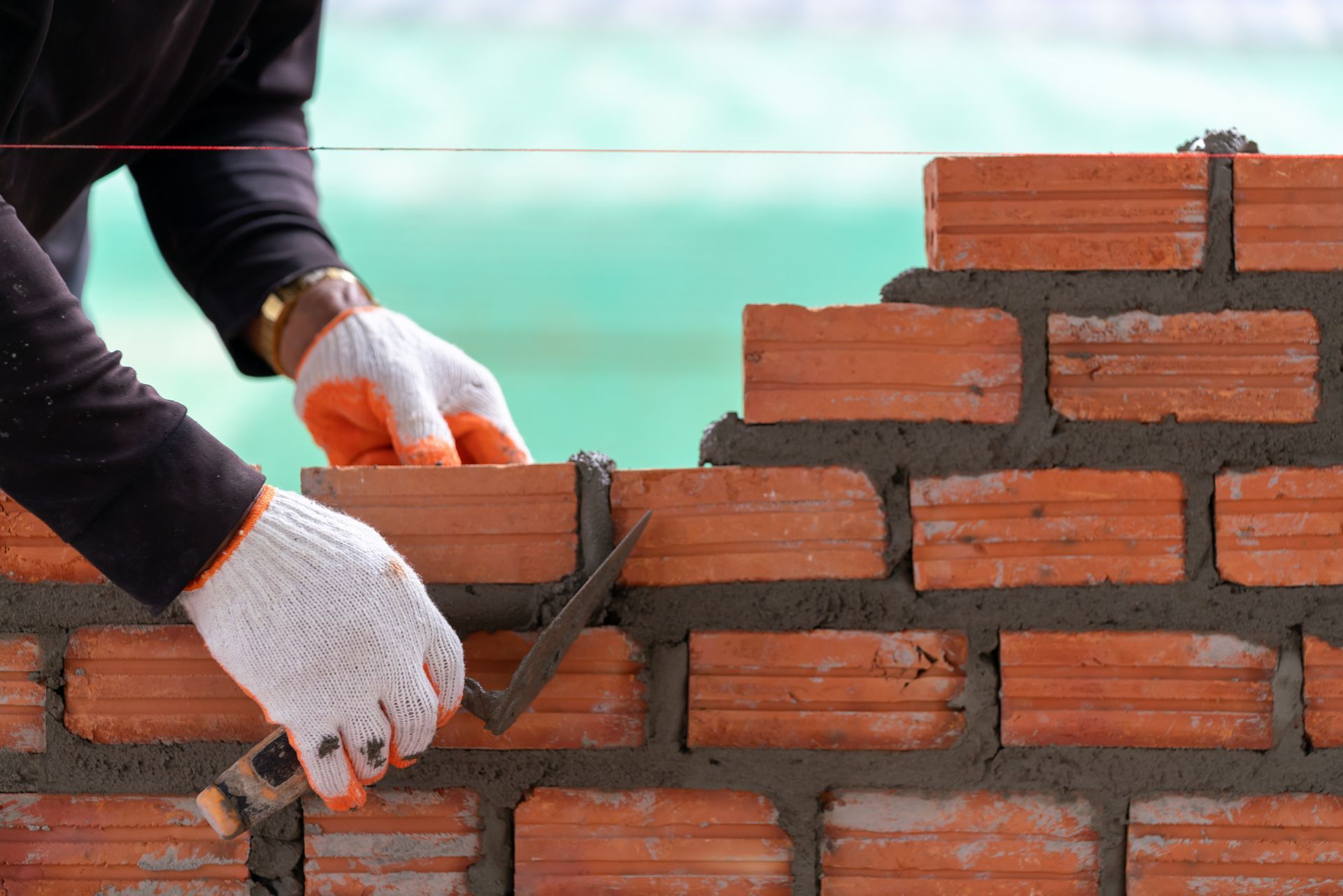 A man is laying bricks on a construction.