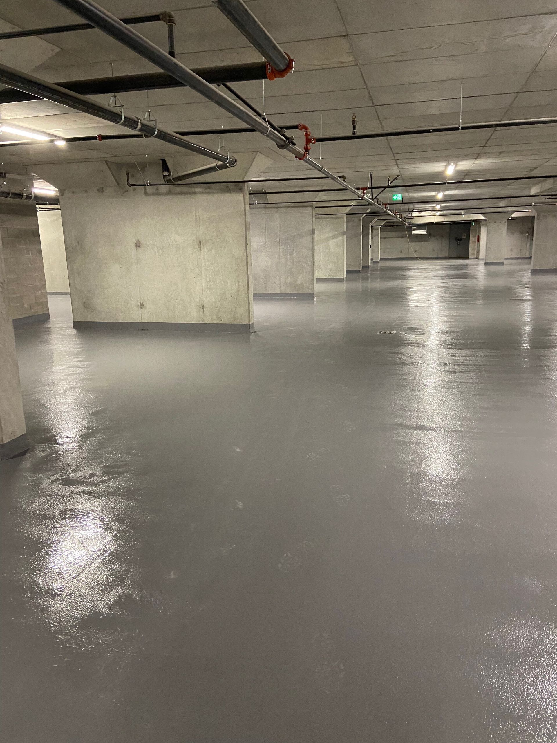 A large empty underground parking garage with a concrete floor.