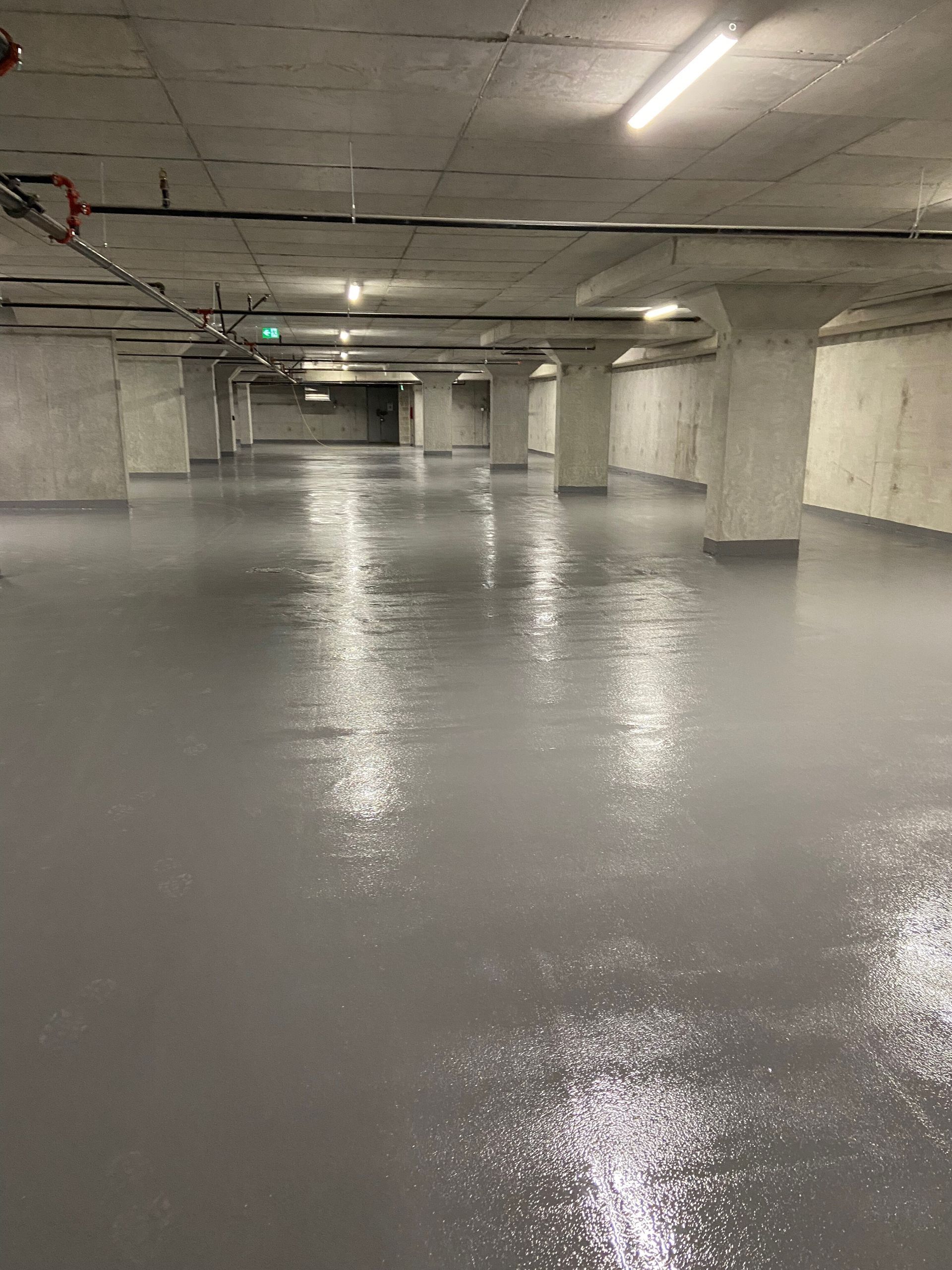 A large empty underground parking garage with a concrete floor.