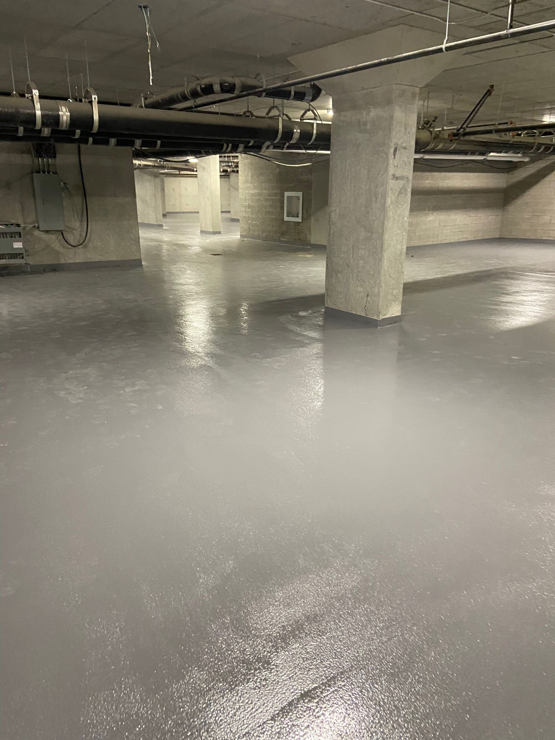 A black and white photo of a flooded underground parking garage.