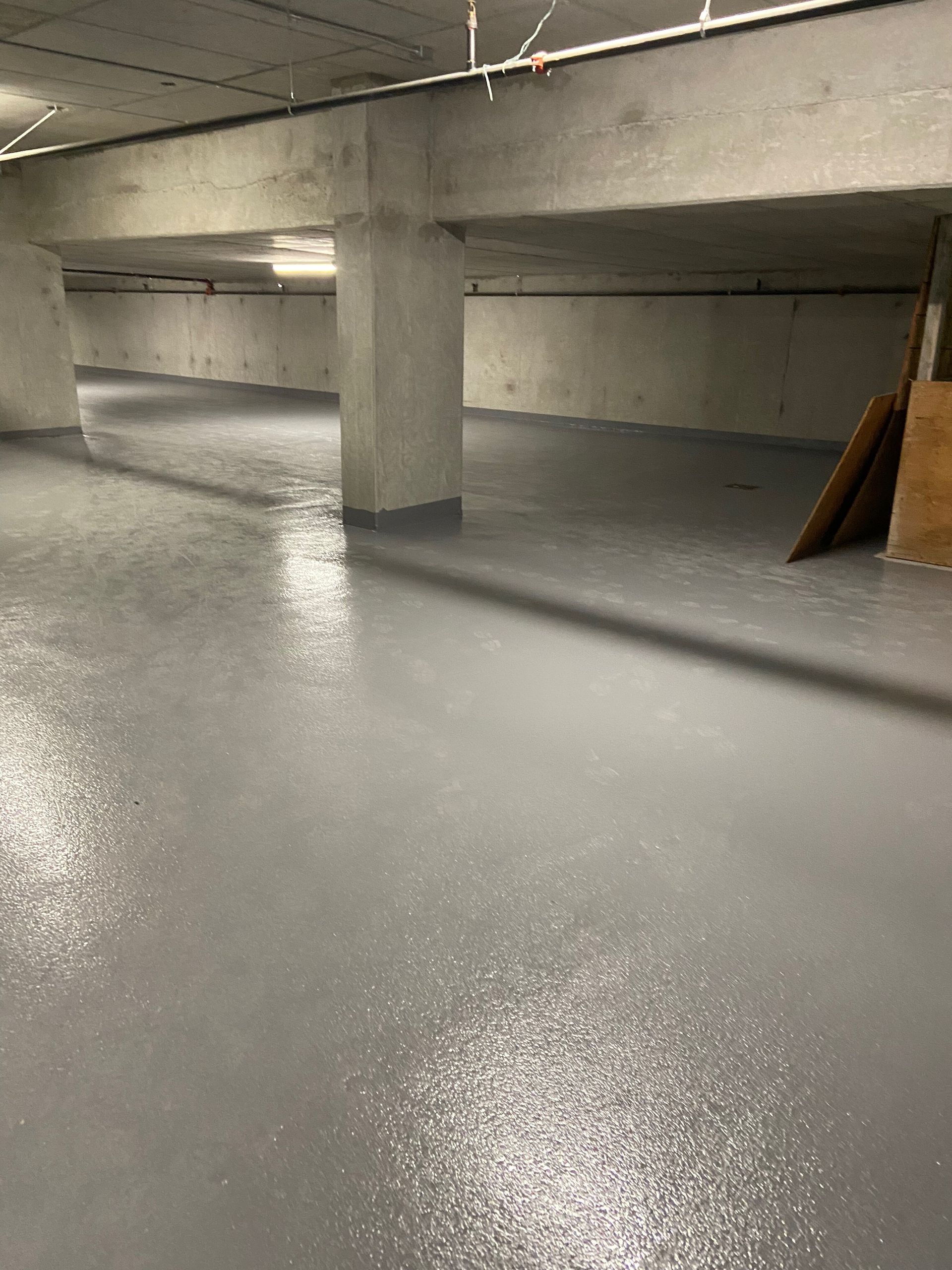 A parking garage with a concrete floor and pillars