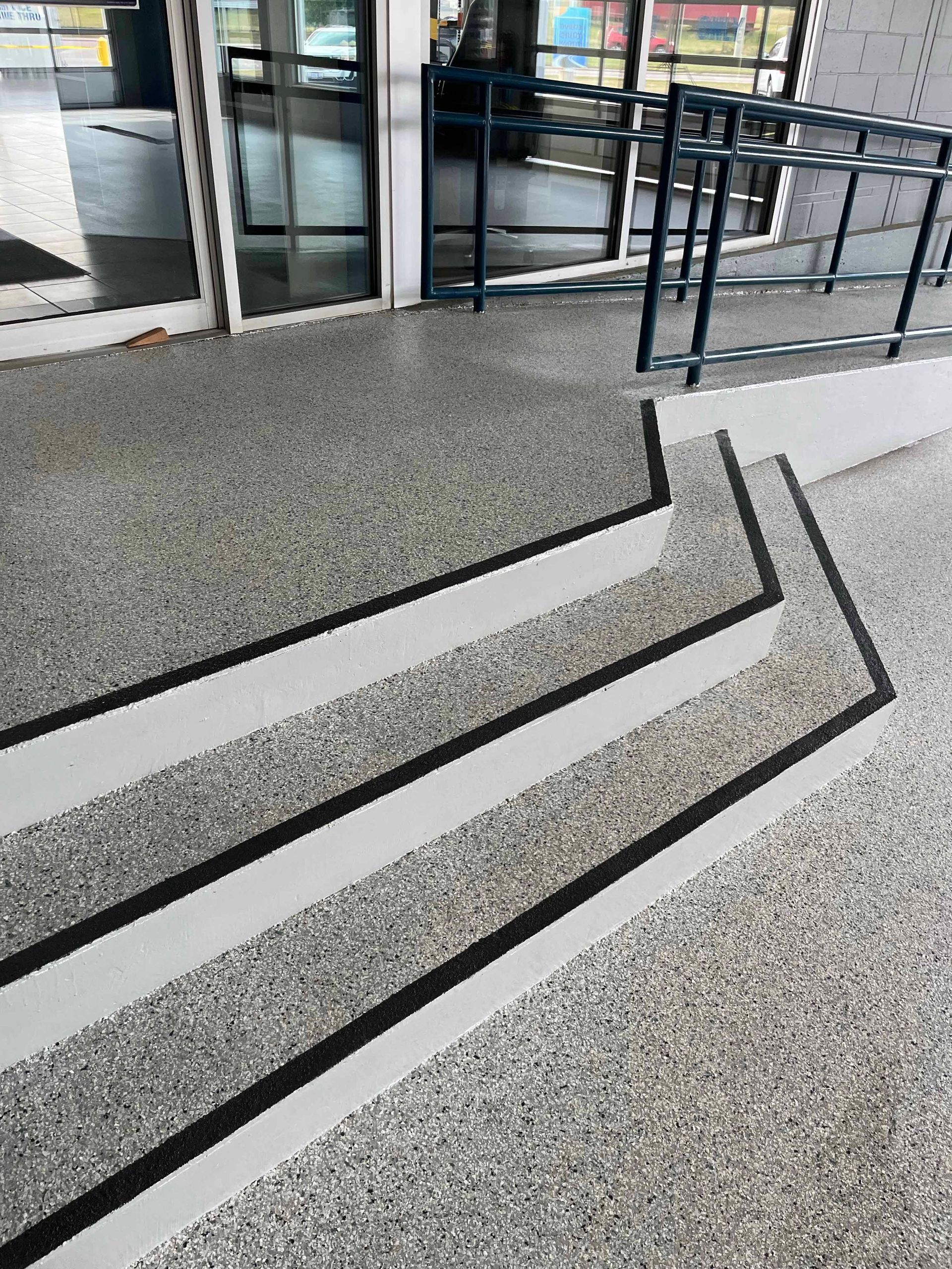 A set of stairs leading up to a building with a ramp.