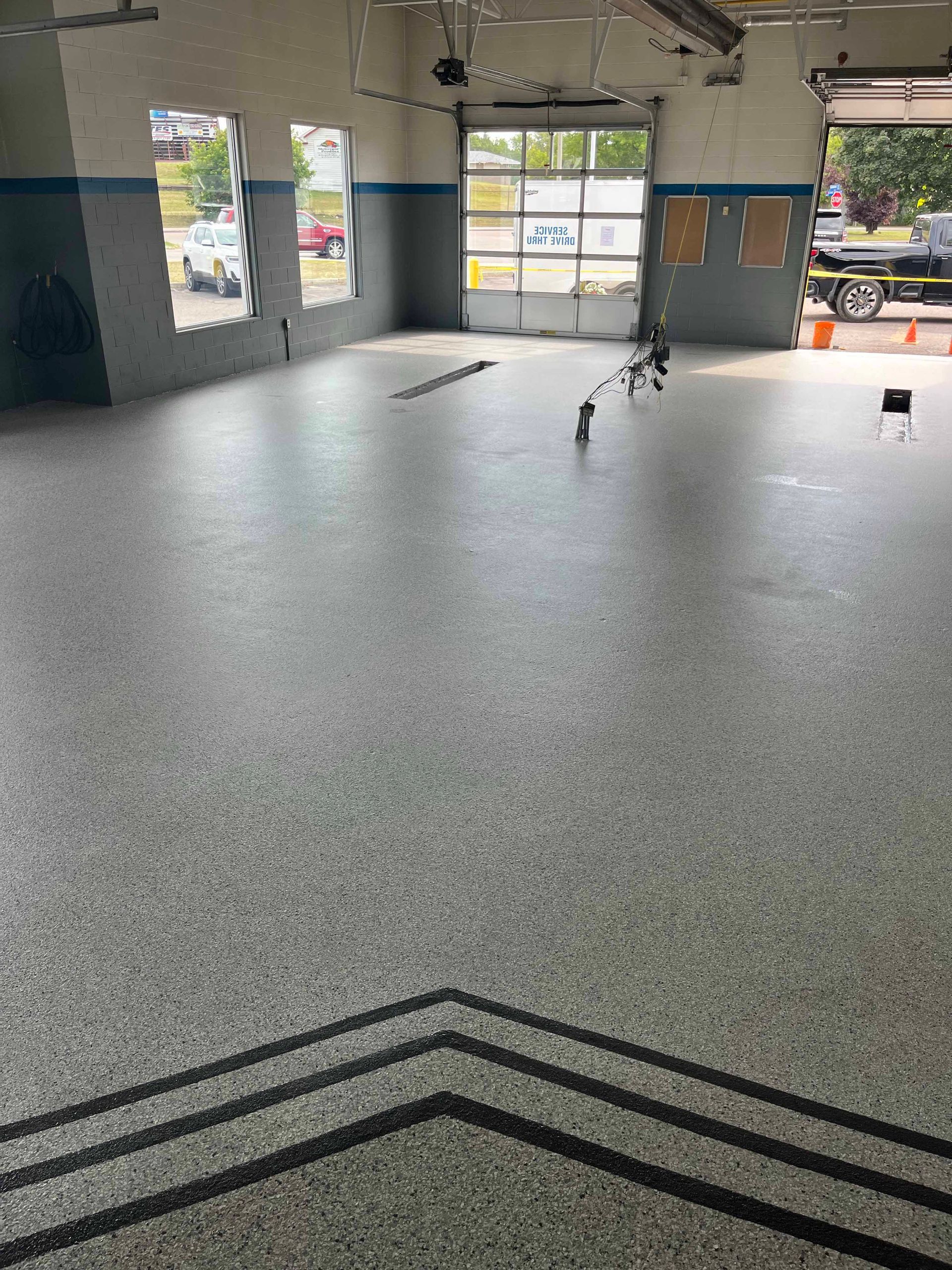 A large empty garage with a chevron pattern on the floor.
