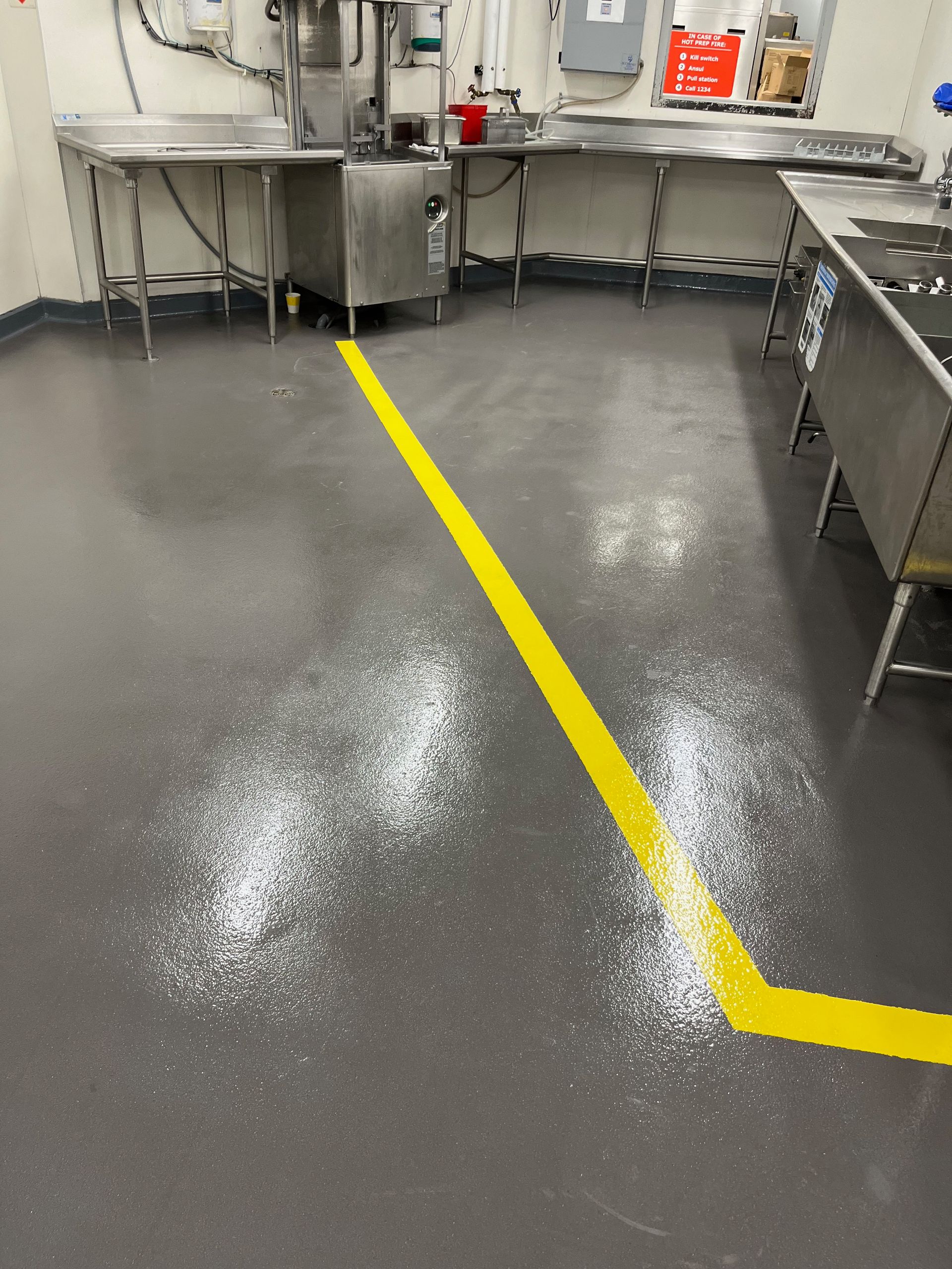 A kitchen with a yellow line on the floor