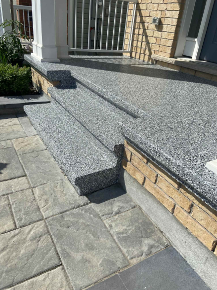 A set of stairs leading up to a porch of a house.