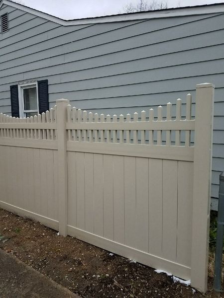 Wooden trash enclosure with gray metal frames and concrete base