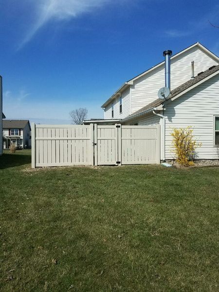 Tan fence encloses a backyard