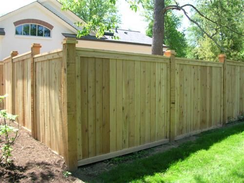 Wooden fence surrounding a grassy yard