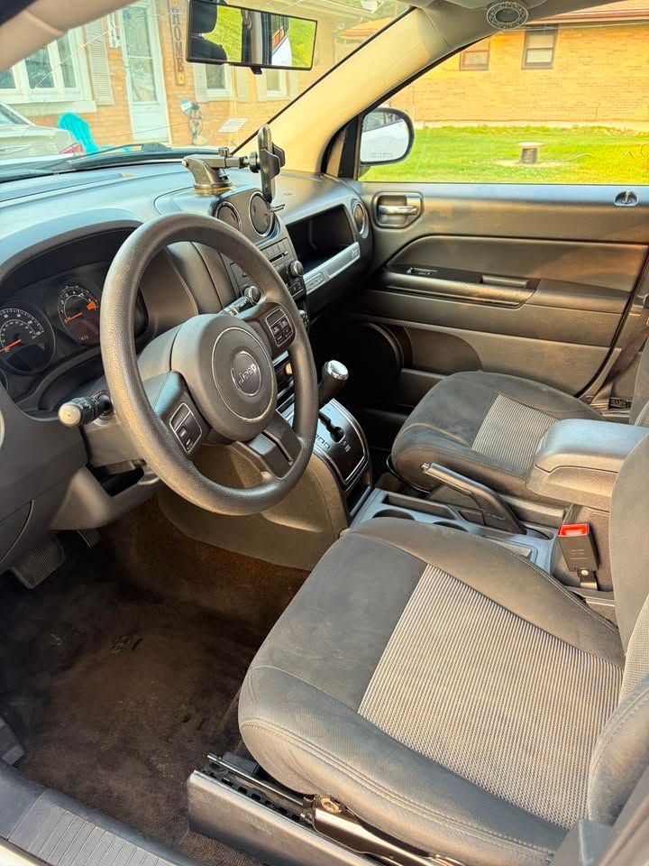 Interior of a black Jeep SUV with front seats, steering wheel, and dashboard visible