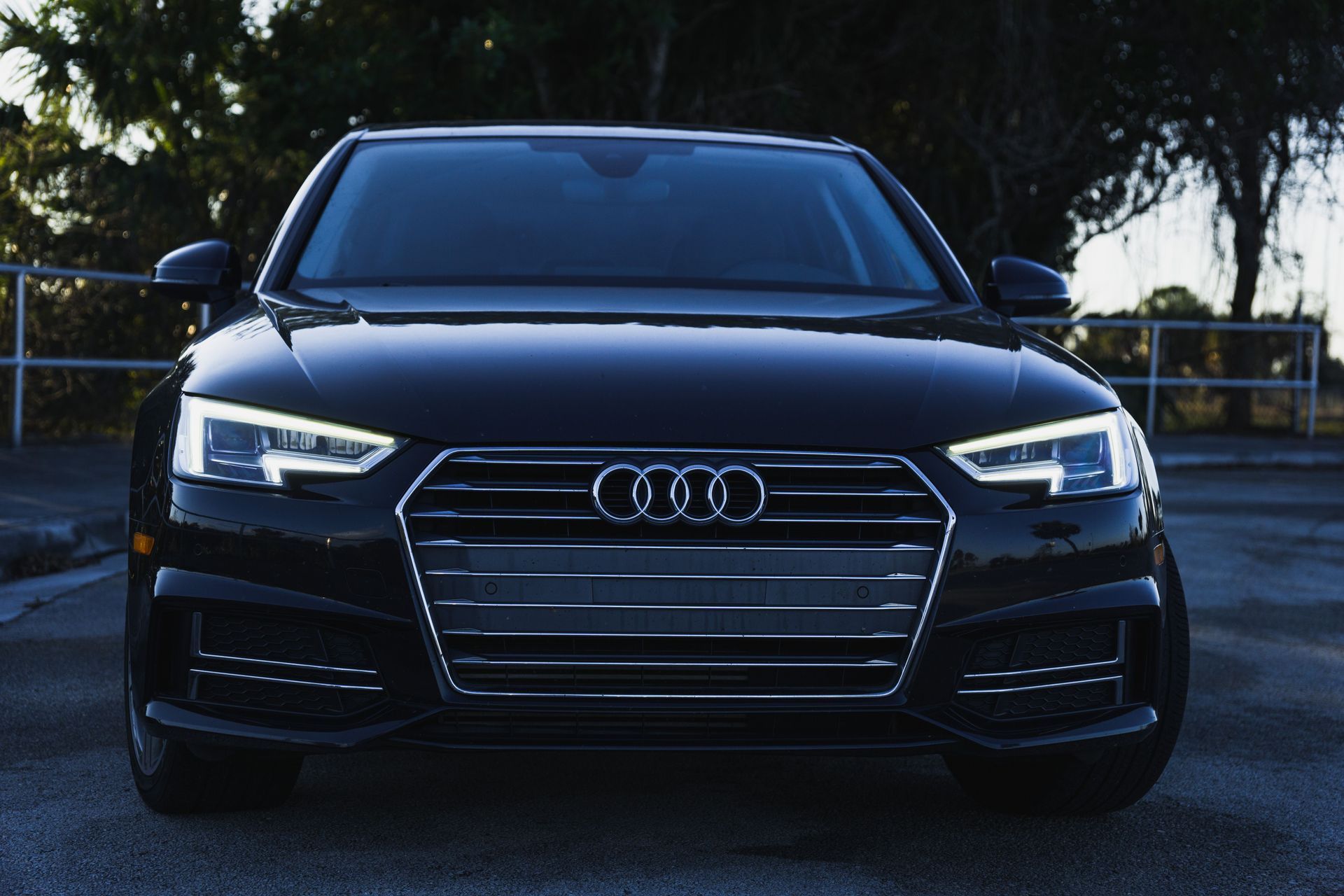 Front view of a black Audi sedan parked outdoors at dusk
